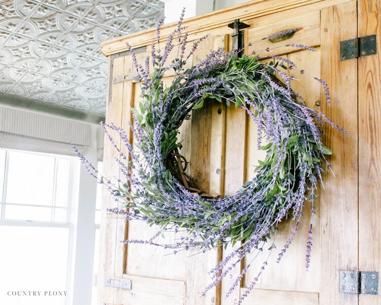 A DIY lavender wreath hangs on a wooden door