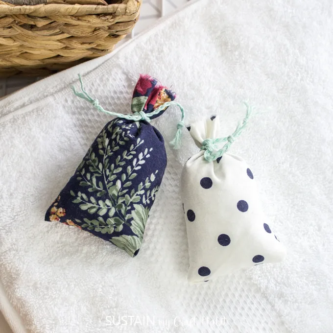 Two homemade lavender sachets sit on a while towel