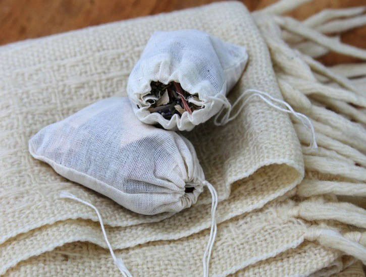 Fabric sachets containing no chemical moth balls sit on a blanket