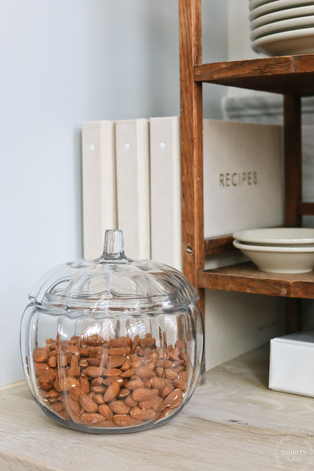 Close up of a glass pumpkin-shaped jar with almonds inside