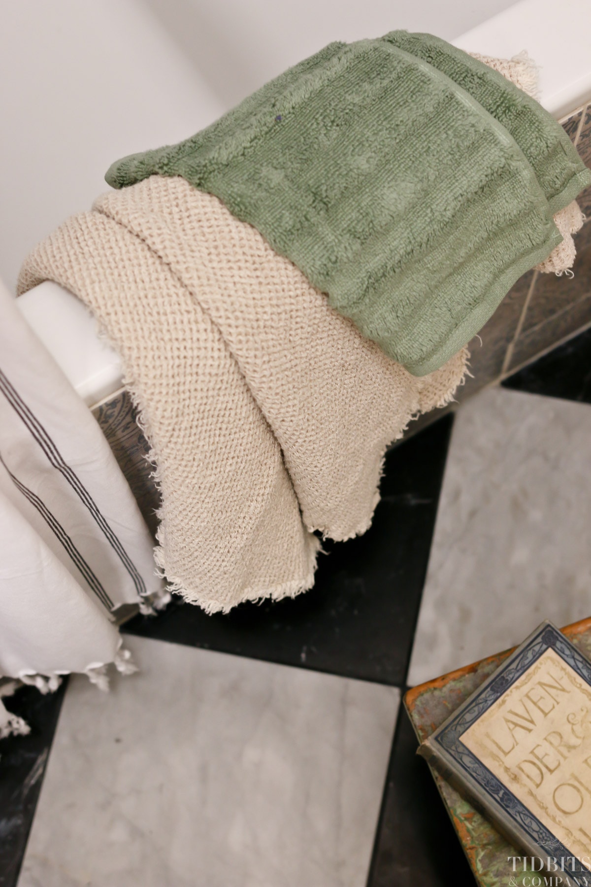 Towels lay over the side of a bathtub