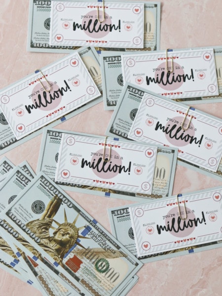 Fake million dollar bills and printable valentines cards for students together on a table