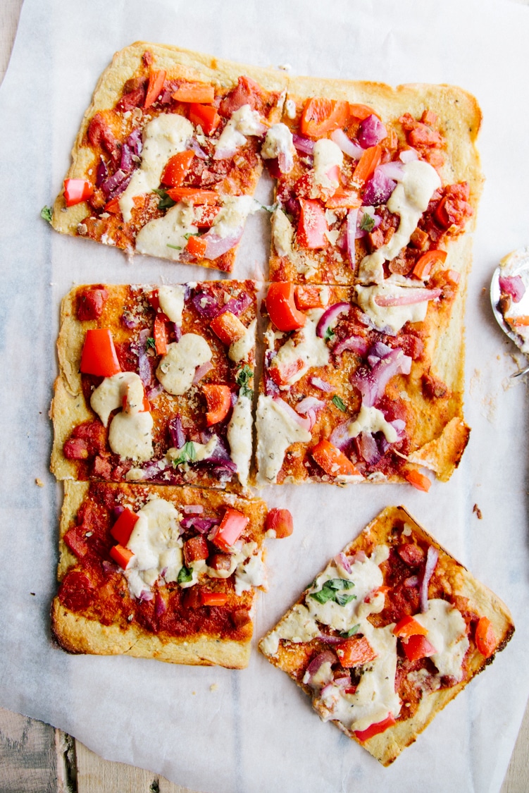 A healthy pizza is sliced into square pieces