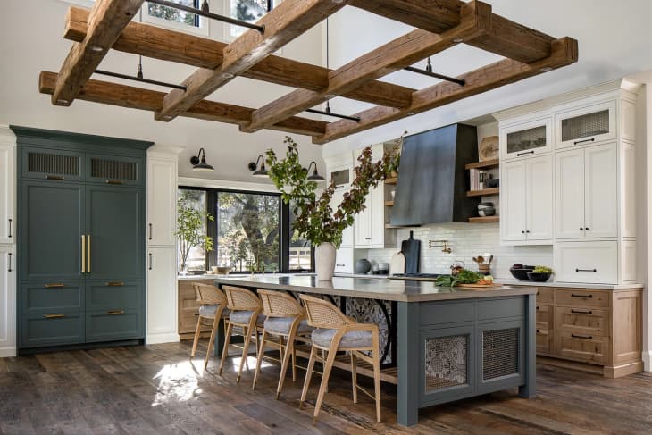 A modern barndominium kitchen with decorative wood beams