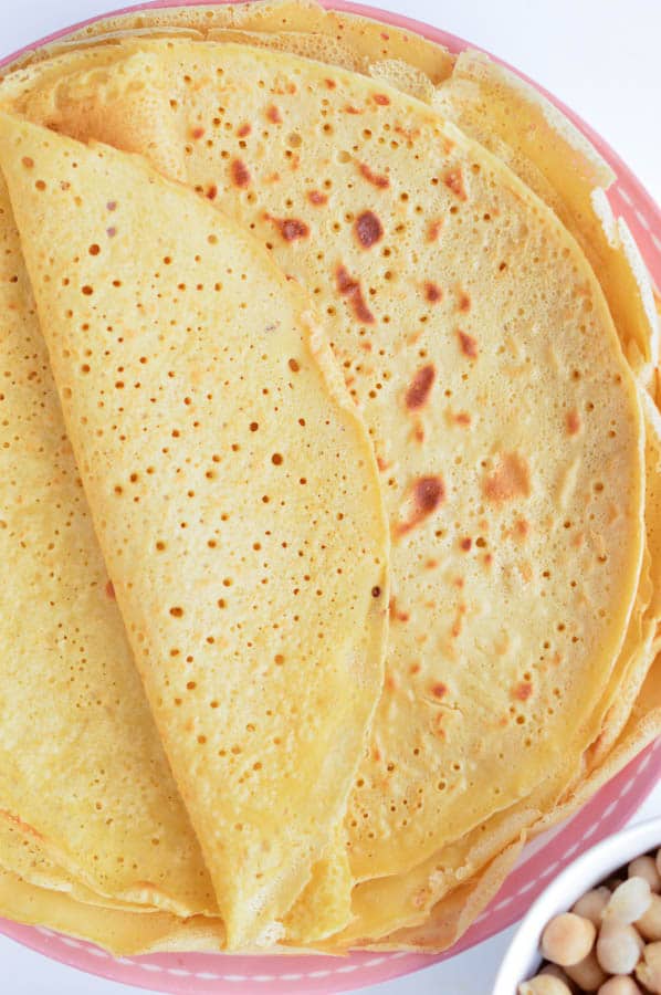 Chickpea crepes are layerd on a plate