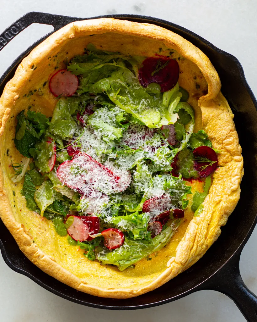 A chickpea flour dutch baby is filled with vegetables and cheese