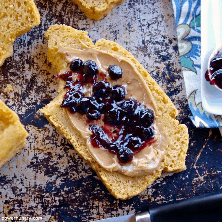 A slice of bread with peanut butter and fruit jam spread on top