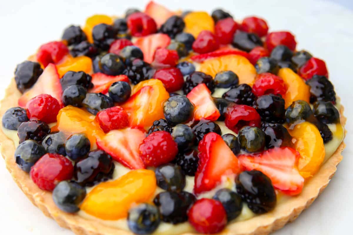 A fruit tart topped with fruit slices and a glaze